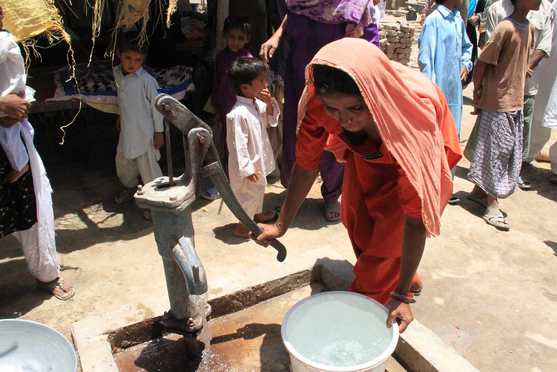 Eine Frau pumpt Wasser aus einem Brunnen. Viele Menschen haben noch immer keinen Zugang zu sauberem Wasser